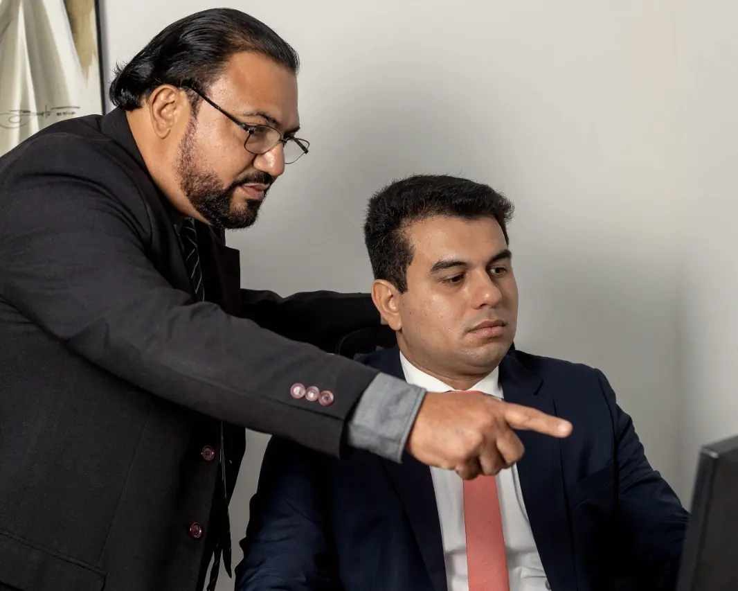 Glaucio H. Alencar aponta para a tela enquanto Linconl Freire analisa um documento no computador